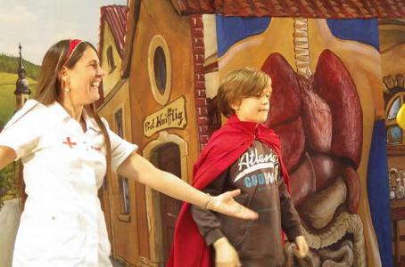 Navid ist stolz darauf, Frau Dr. Helfefix zu assistieren und Prof. Knifflig zu zeigen, wie man sich gesund ernährt. Foto: Birgid Weiß
